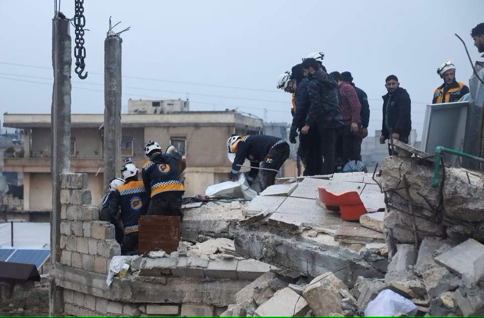 Lực lượng cứu hộ tìm kiếm những người sống sót dưới đống đổ nát của một tòa nhà bị hư hại, sau trận động đất, ở Azaz, Syria – khu vực do quân nổi dậy kiểm soát