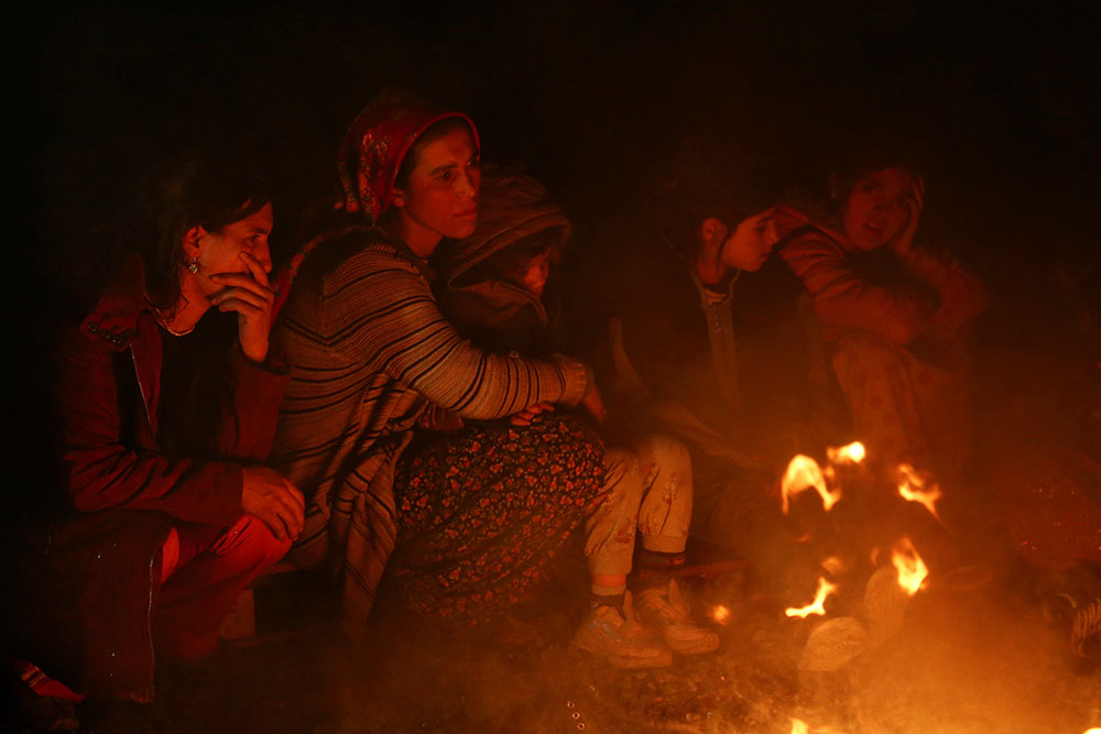 Một số phụ nữ và trẻ em ngồi quanh đống lửa ở Kahramanmaraş, Thổ Nhĩ Kỳ để xua tan cái lạnh thấu xương. Trên gương mặt của mỗi người không giấu được tuyệt vọng, thẫn thờ sau trận động đất mạnh 7,8 độ richter cướp đi sinh mạng của hơn 3.800 người tại Thổ Nhĩ Kỳ và Syria.