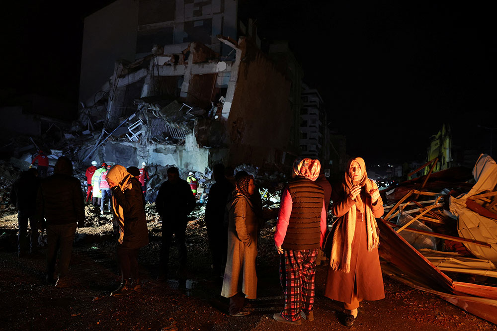 Mọi người tập trung gần một tòa nhà bị sập ở Iskenderun, Thổ Nhĩ Kỳ, chờ đợi lực lượng cứu hộ đưa những người thân của họ ra khỏi đống đổ nát.