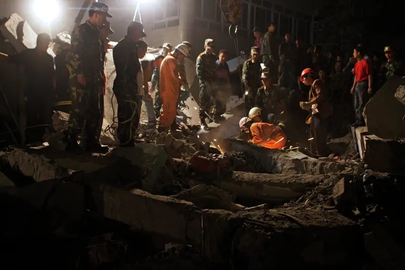 Lực lượng cứu hộ tìm kiếm các nạn nhân tại một trường học bị sập sau trận động đất ở tỉnh Tứ Xuyên vào ngày 12/5/2008