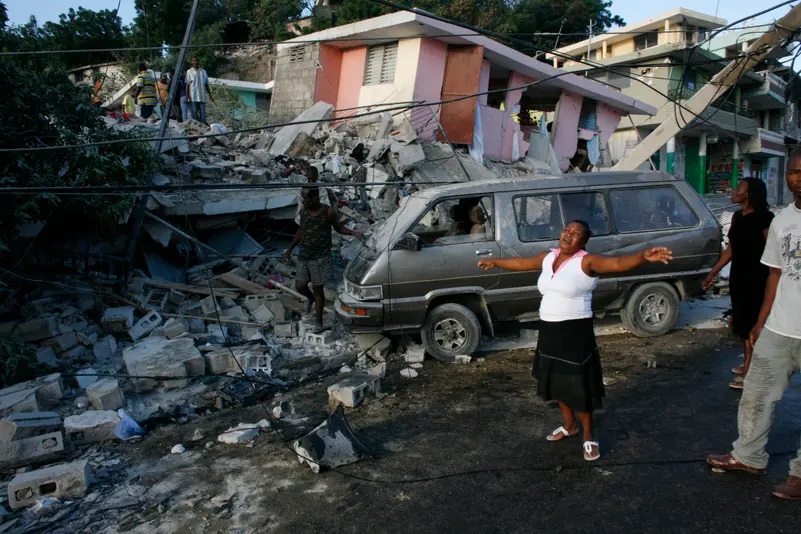 Một người phụ nữ suy sụp khi đứng gần những tòa nhà bị phá hủy sau trận động đất ở Port-au-Prince, Haiti vào ngày 13/01/2010