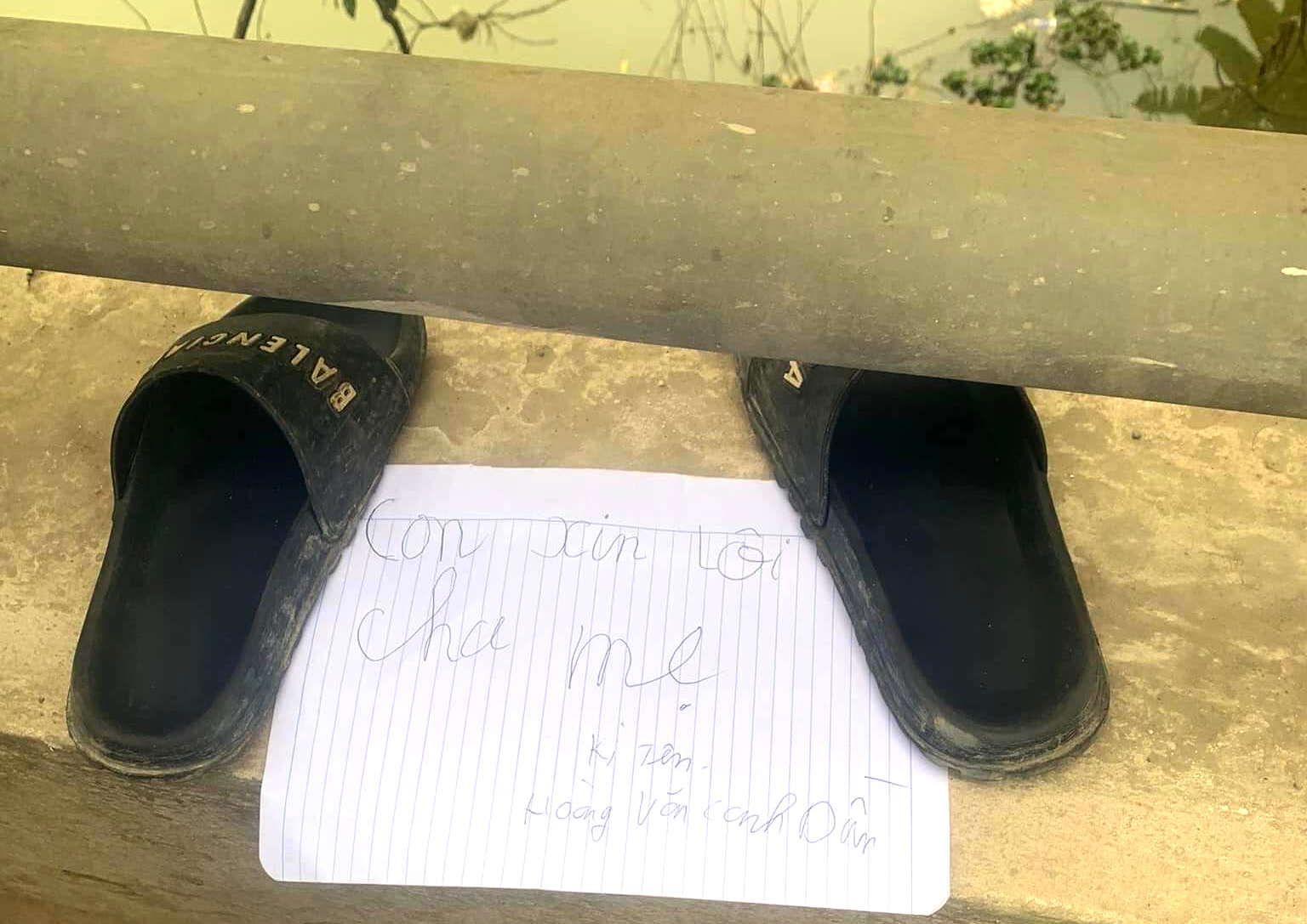 Mảnh giấy xin lỗi cha mẹ cùng đôi dép để lại trên cầu khiến nhiều người dân lo lắng đi tìm kiếm - Ảnh: Nguyễn Viết
