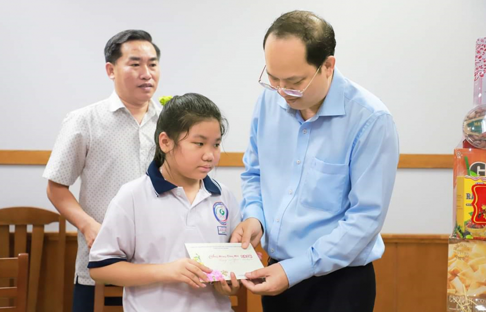 Phó bí thư Thành ủy TPHCM Nguyễn Hồ Hải thăm, chia sẻ mất mát và động viên  em Phạm Lê Mẫn Nhi - ẢNH: TUYẾT DÂN