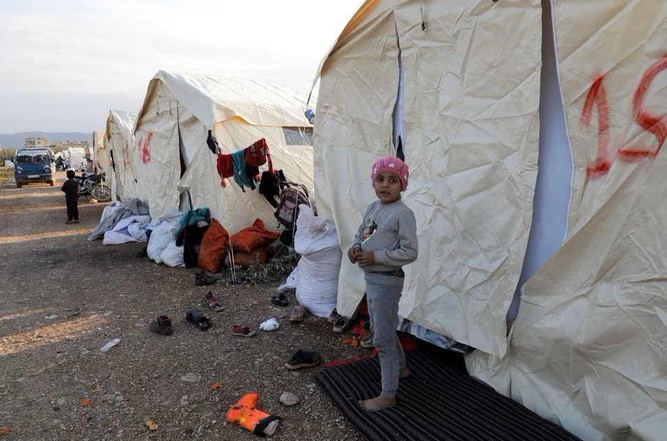 Một đứa trẻ đứng bên ngoài những chiếc lều được dựng lên cho những người bị ảnh hưởng bởi trận động đất kinh hoàng, tại thị trấn Jandaris do phe nổi dậy kiểm soát, Syria