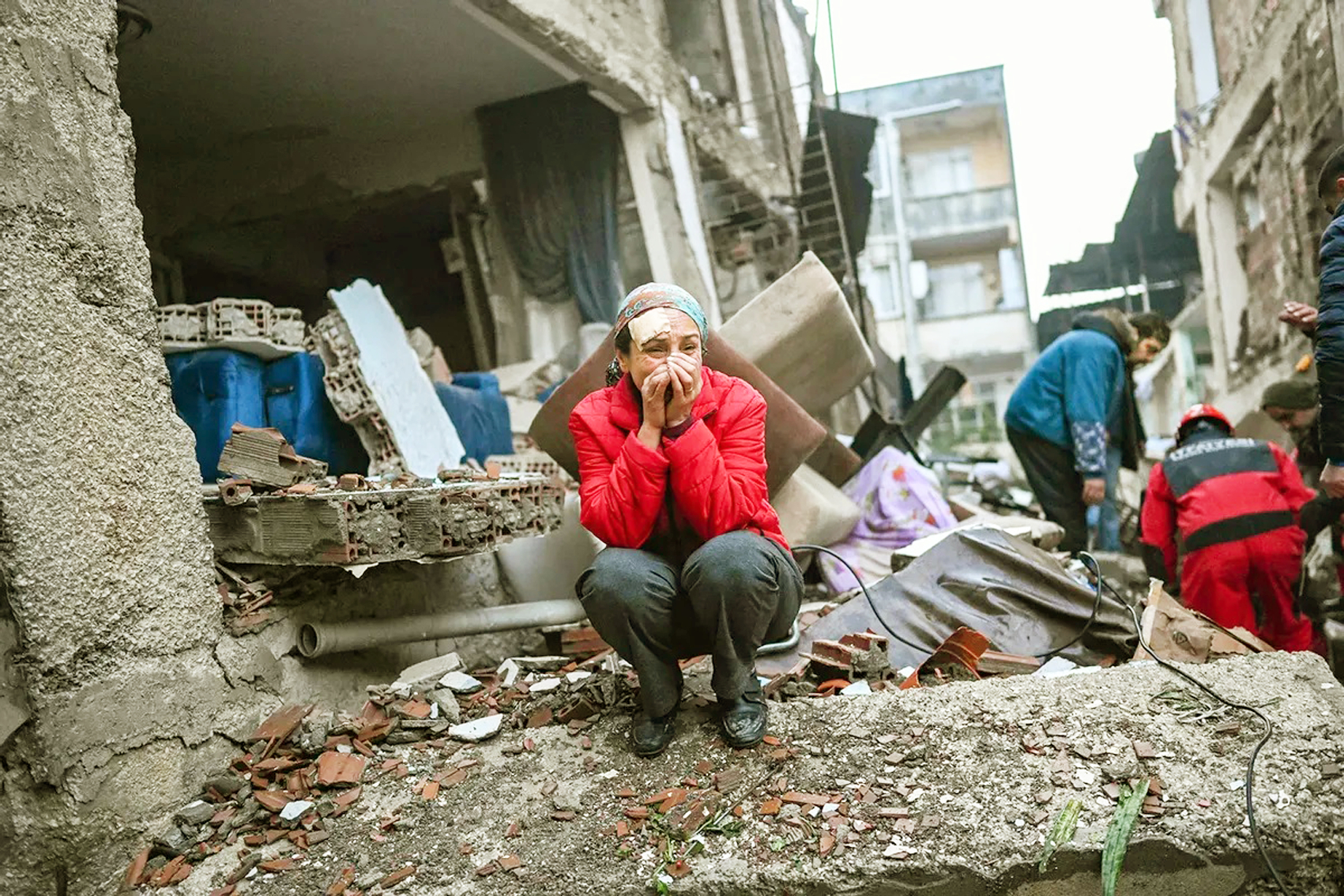Một phụ nữ sống sót sau trận động đất không kìm được nước mắt trong khi lực lượng cứu hộ nỗ lực tìm kiếm nạn nhân và những người sống sót khác ở Hatay, Thổ Nhĩ Kỳ - ẢNH: AFP