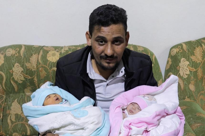 Anh Khalil Al-Sawadi, chú của bé gái sinh ra trong trận động đất Thổ Nhĩ Kỳ-Syria, bế cô (phải) và con gái mới sinh của mình (trái), ở Jandaris, Syria.