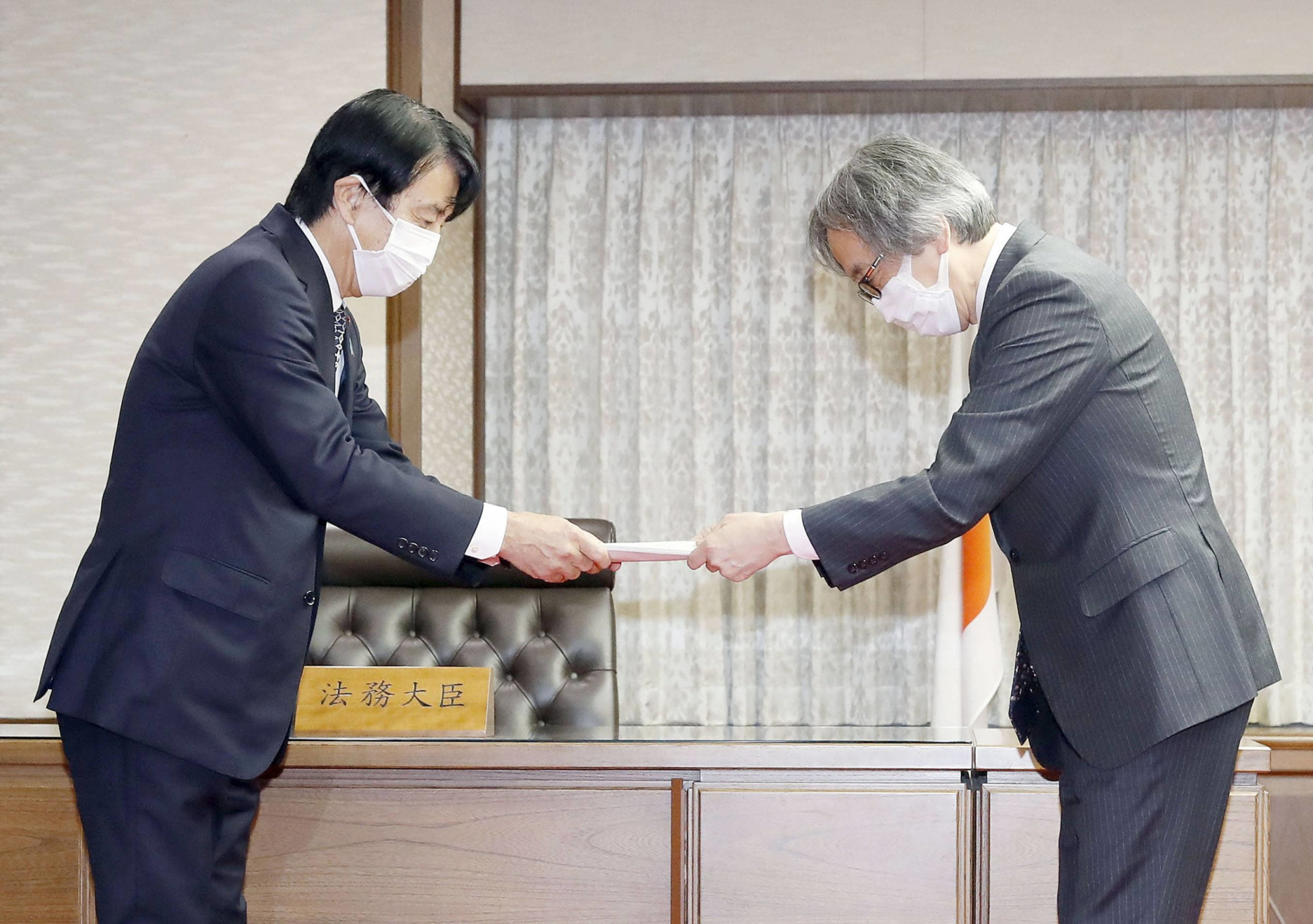 Bộ trưởng Tư pháp Ken Saito (trái) nhận bản kiến nghị thay đổi độ tuổi đồng thuận tình dục từ đại diện hội đồng chuyên môn hôm 17/2 tại Tokyo - Ảnh: Kyodo