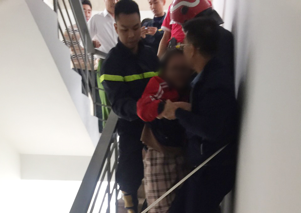 Đội Cảnh sát PCCC&CNCH Công an quận Hoàng Mai đưa cháu bé bàn giao cho gia đình an toàn