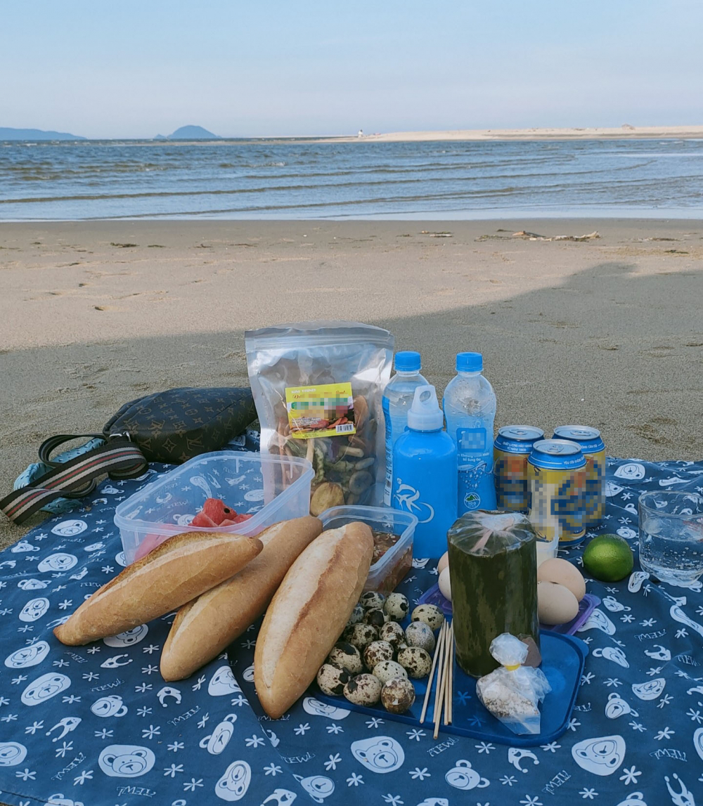 Chỉ cần một tấm thảm picnic cũng đủ để tạo nên một bữa tiệc nhỏ ấm áp nhưng không kém phần lãng mạn trên bãi biển