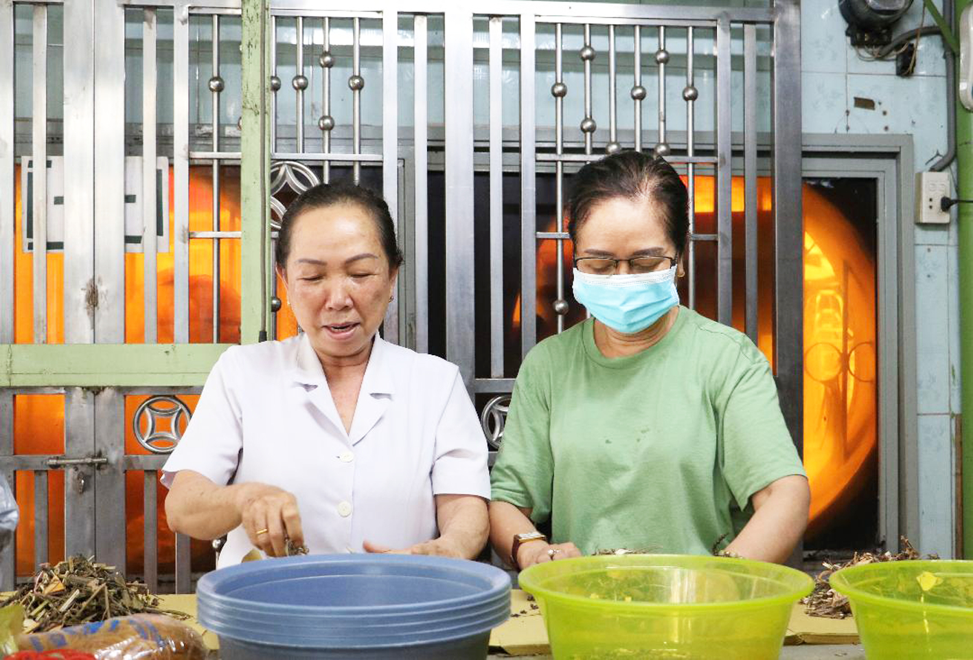 Lương y Trương Thị Ánh Nhung (bên trái) bốc thuốc cho bà con