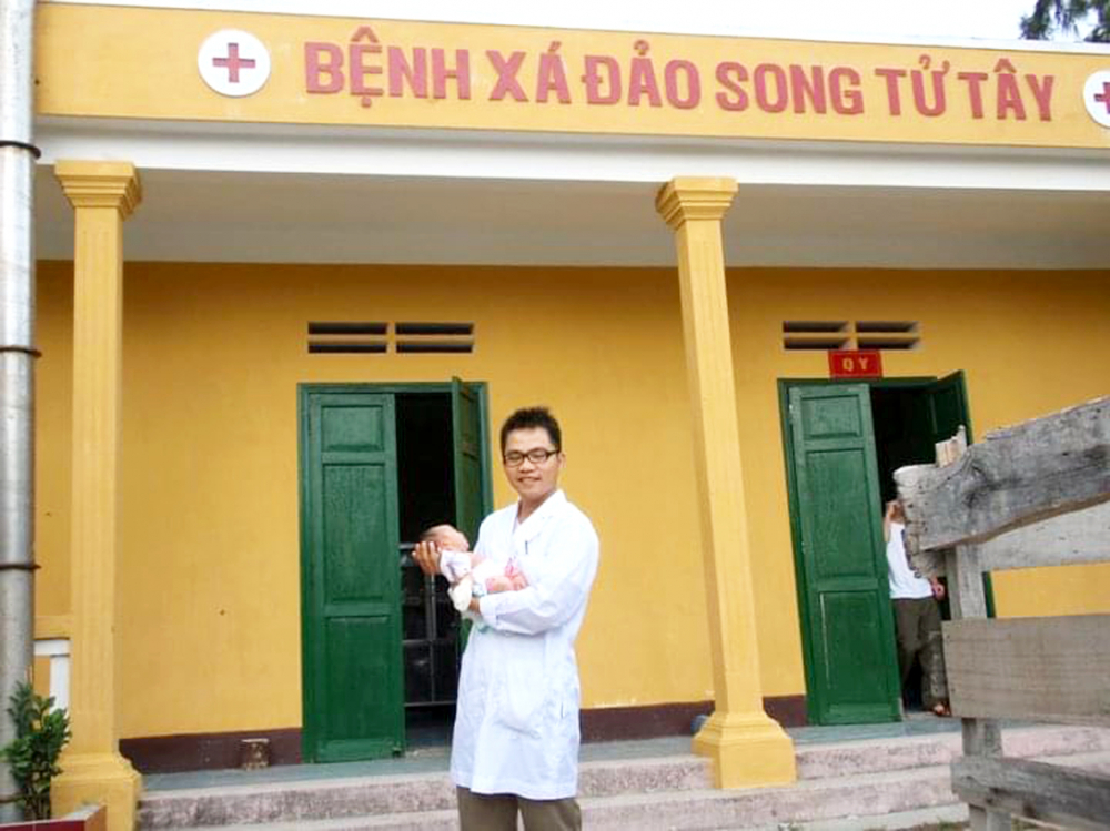 Bác sĩ Nguyễn Lê Minh Đạt bế công dân đầu tiên được sinh tại quần đảo Trường Sa - ẢNH: BSCC