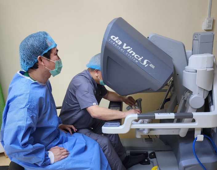 Bác sĩ Philippines đang thao tác tại bàn điều khiển hệ thống robot phẫu thuật  dưới sự hướng dẫn của Bác sĩ Nguyễn Phú Hữu, ảnh BVCC