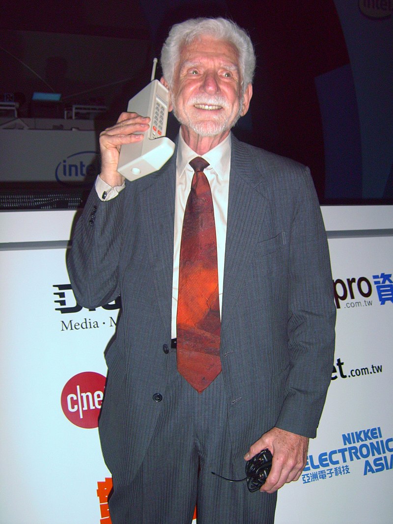 Tiến sĩ Martin Cooper đang cầm trên tay chiếc điện thoại di động Motorola DynaTAC do ông phát minh cách đây 50 năm - Ảnh: Bởi Rico Shen, CC BY-SA 3.0
