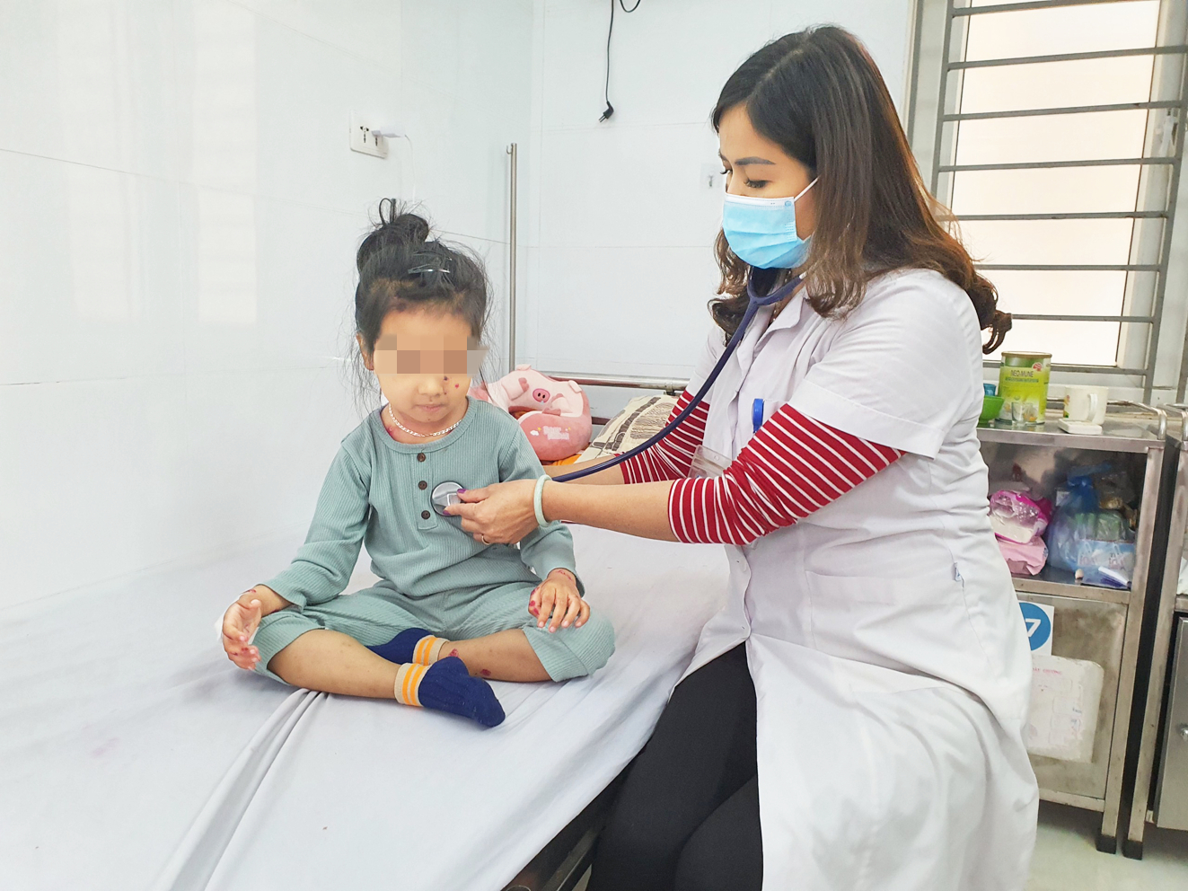Bác sĩ Trần Thị Kim Anh thăm khám cho bệnh nhi thủy đậu đang điều trị tại Khoa Nhiệt đới  (Bệnh viện Đa khoa Hà Đông) - ẢNH: H.A