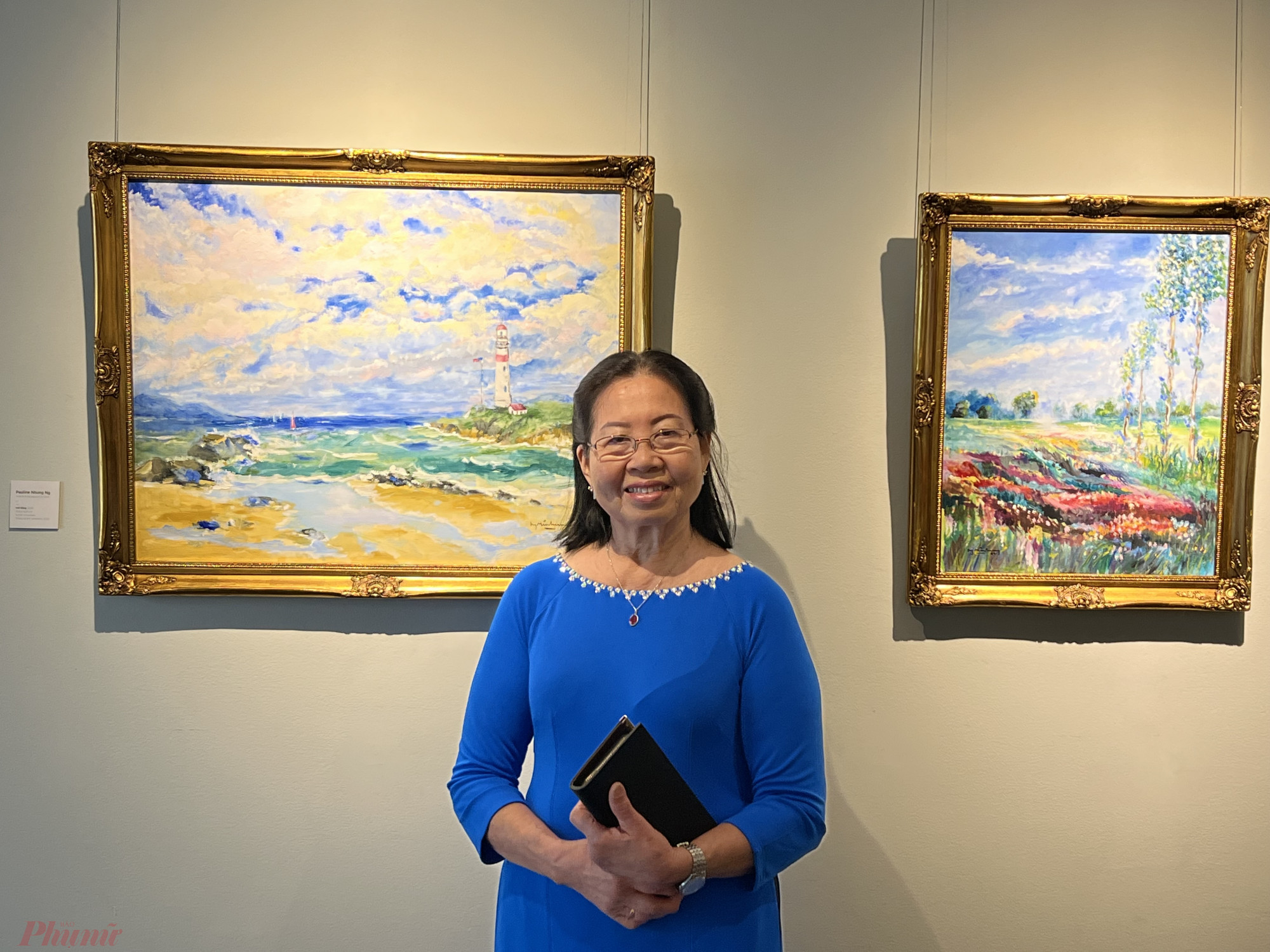 Bà Pauline Nhung Nguyễn bên 2 bức tranh mà bà đã vẽ