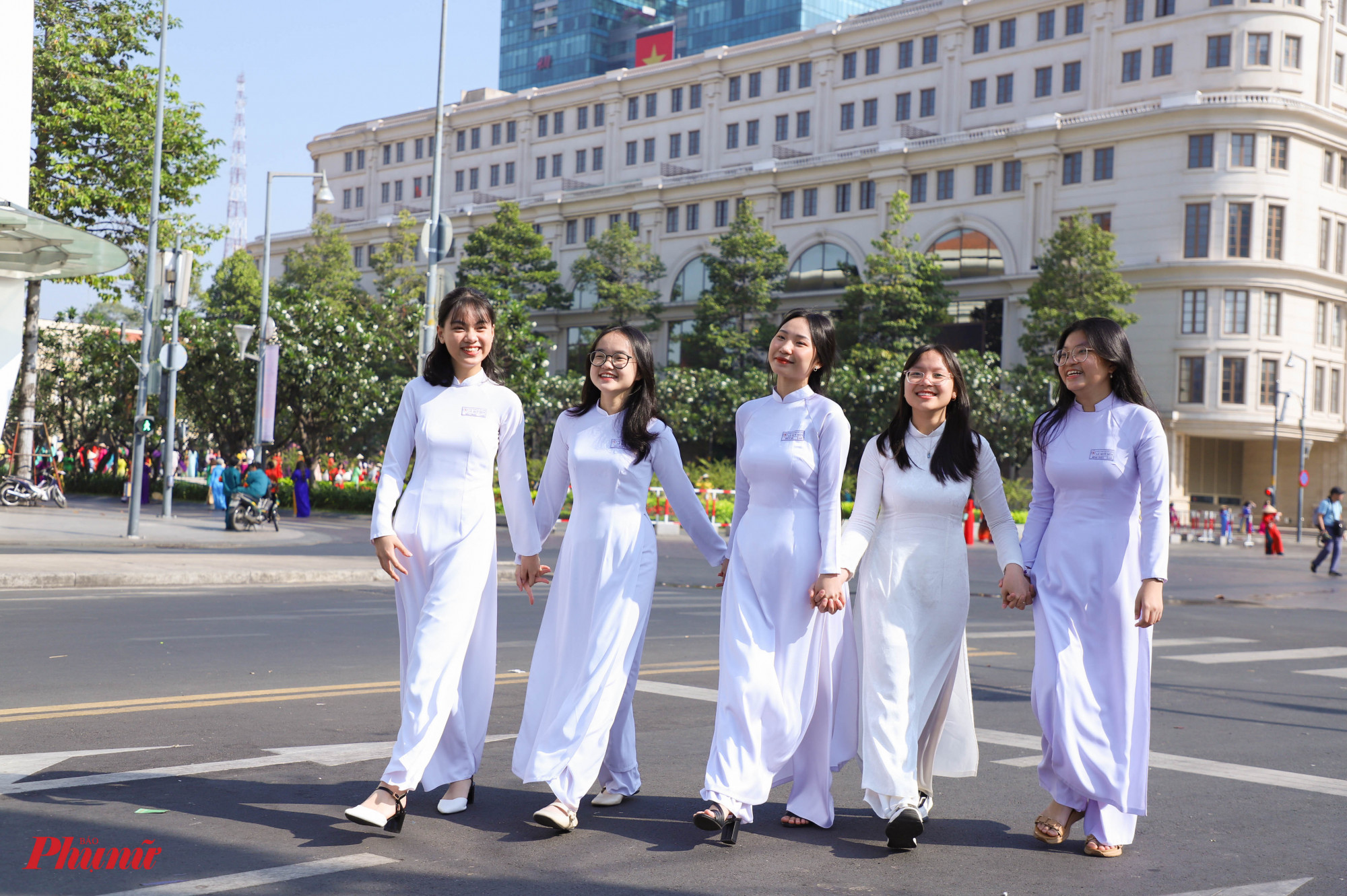 Nhiều nữ sinh cũng tham gia diễu hành trong tà áo dài trắng thướt tha. Các em cũng tranh thủ ghi lại nhiều khoảnh khắc đẹp tại trung tâm TPHCM vào dịp cuối tuần mát mẻ, sôi động.