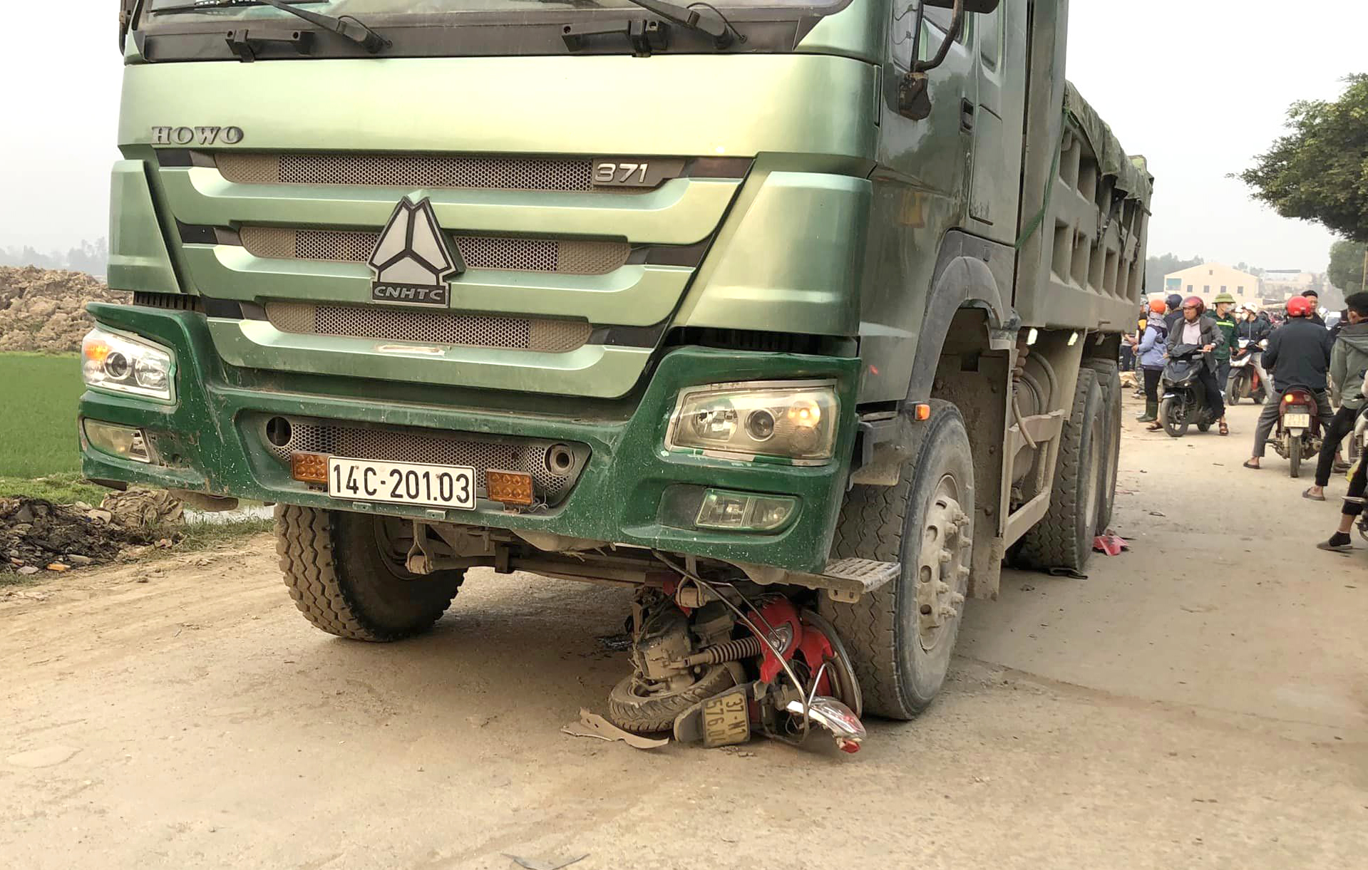 Chiếc xe máy nằm lọt dưới gầm xe tải sau tai nạn - Ảnh: Khánh Trung