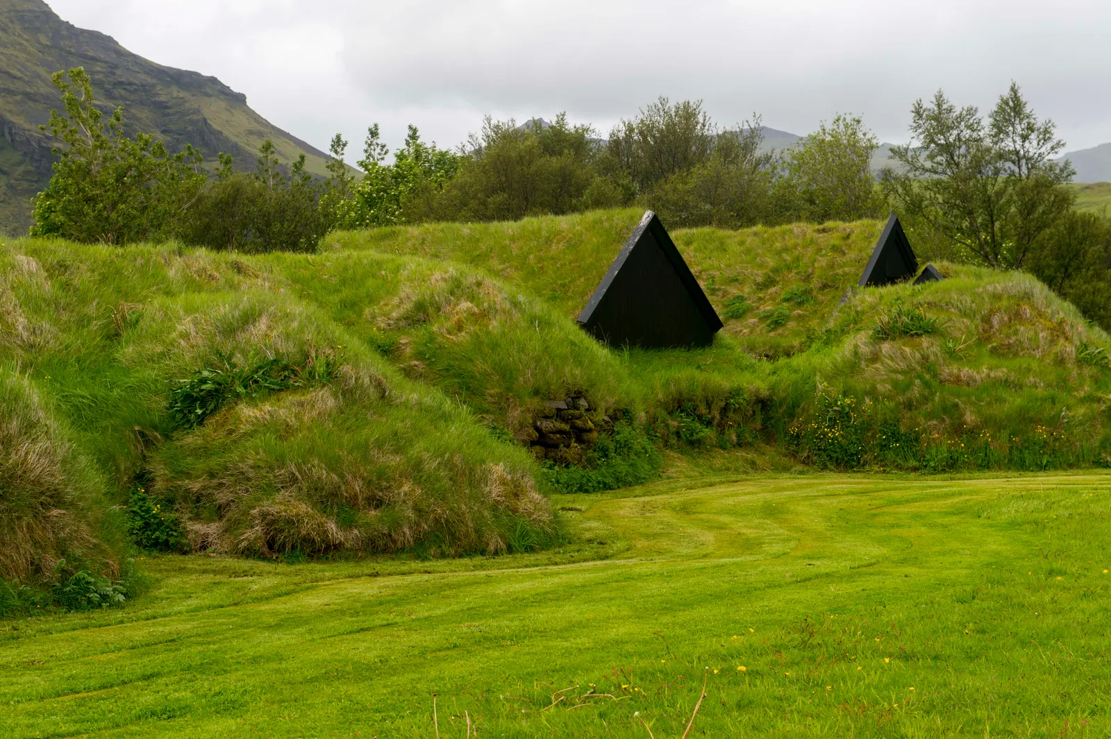 Turf Houses (Iceland) Nhà cỏ (Iceland)  Mặc dù xinh đẹp, địa hình của Iceland đặc biệt khó sinh sống, đó là lý do tại sao nó vẫn là một trong những  quốc gia ít dân cư nhất ở châu Âu. Trên thực tế, những ngôi nhà bằng cỏ giống như những ngôi nhà được thấy ở trên, là một lý do lớn khiến những người định cư Bắc Âu ban đầu có thể thành lập cộng đồng trên đảo. Được thiết kế như những cấu trúc gỗ đơn giản, các bức tường và mái nhà được làm bằng những khối cỏ, điều này cũng giúp ngụy trang cho những ngôi nhà nếu bạn không biết mình đang tìm kiếm thứ gì. Mặc dù chúng có thể được tìm thấy trên khắp hòn đảo và nhiều ngôi nhà có niên đại hơn một trăm năm, nhưng nhóm nhà cỏ rộng lớn nhất được tìm thấy ở Glaumbær.