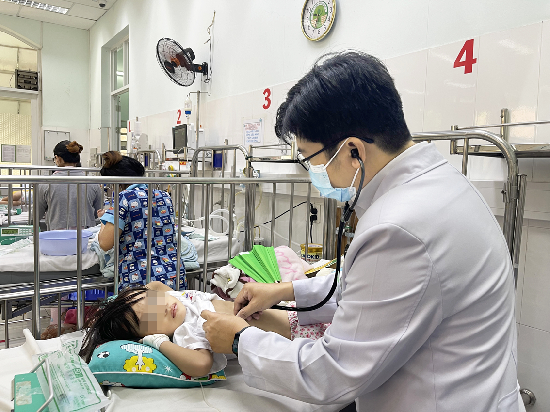 Bác sĩ Nguyễn Hoàng Phong - Trưởng khoa Hô hấp 1 Bệnh viện Nhi Đồng 2 - đang khám cho một trường hợp nhập viện vì viêm phổi - ẢNH: THANH HUYỀN