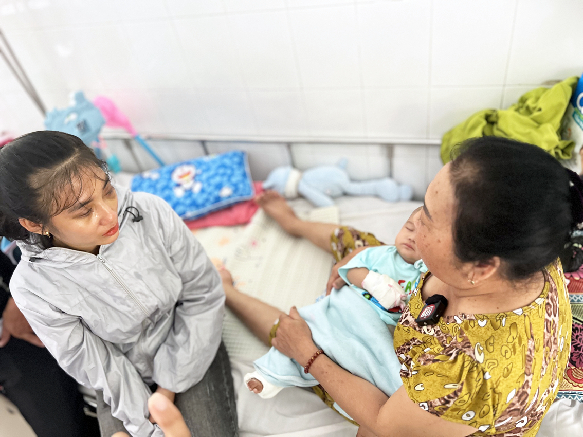 Lưu Thị Huyền Trang (bên trái) thăm cháu Y. đang điều trị tại Bệnh viện Nhi Đồng 2