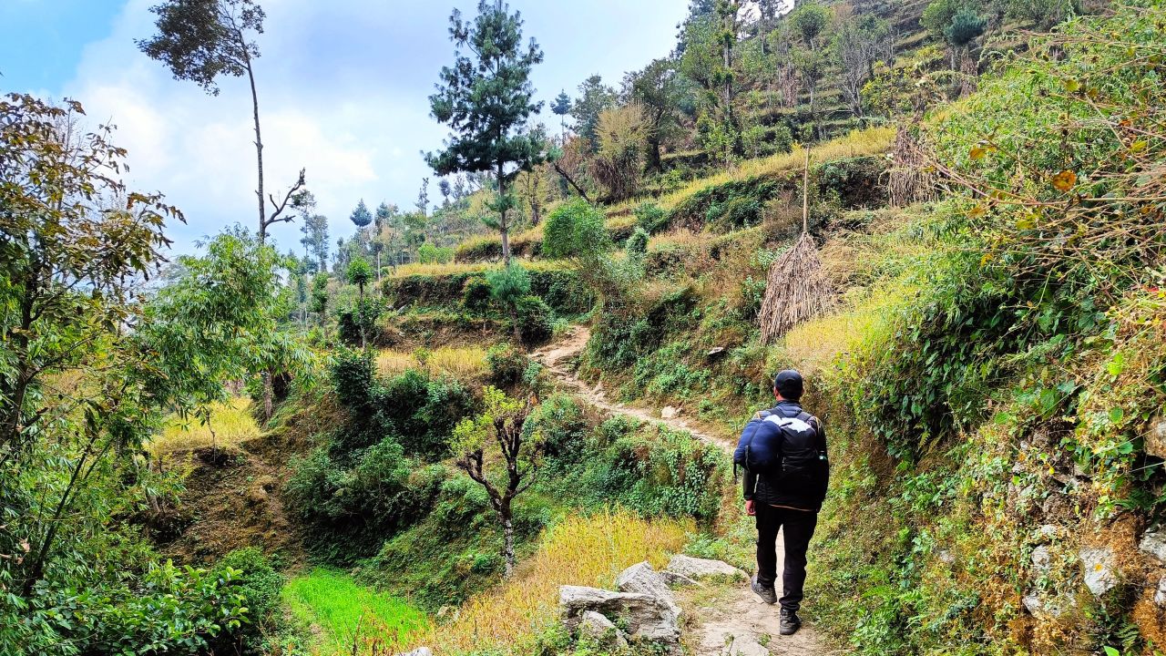 Người đàn ông đi bộ đường dài giữa cảnh quan nông thôn của Thung lũng Nepal