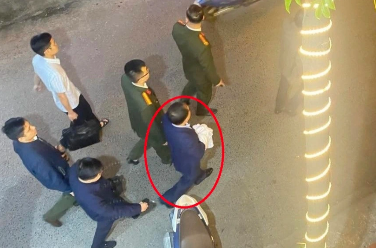 Cơ quan điều tra dẫn giải ông Nguyễn Đình Đương (khoanh tròn đỏ) ra xe tối 13/3.
