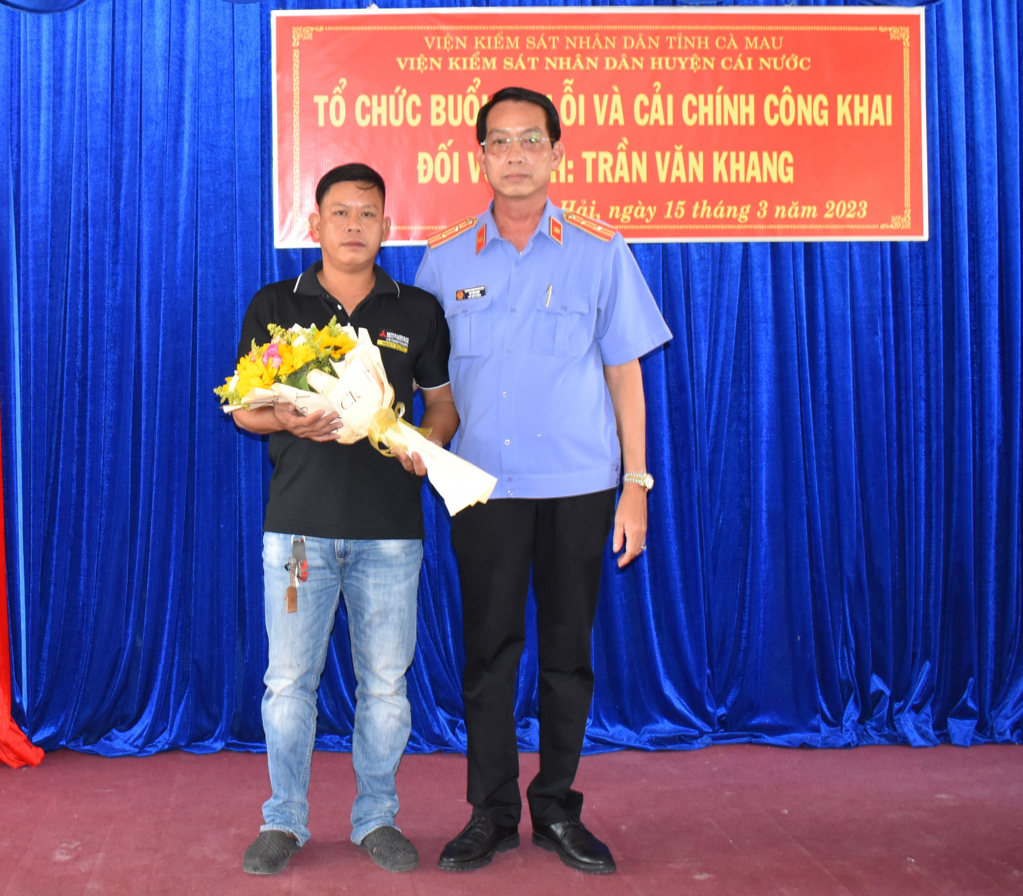 Đại diện cơ quan tố tụng huyện Cái Nước tặng hoa trong buổi xin lỗi ông Khang