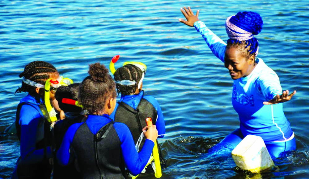 Zandile Ndhlovu đang hướng dẫn trẻ em về cách lặn với ống thở - ẢNH: JULIA EVANS