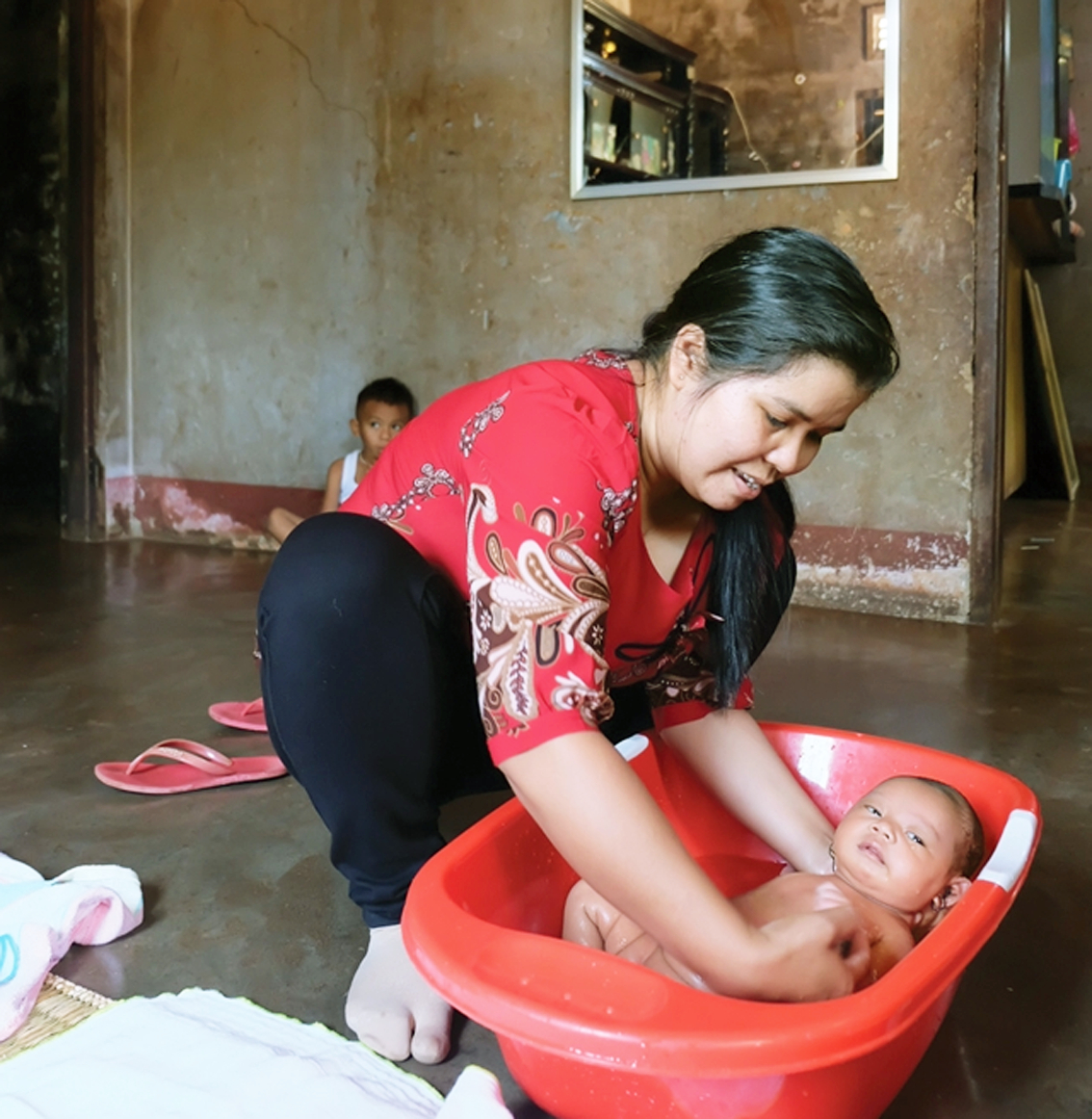 Cô đỡ H-Đông đang chăm sóc em bé sơ sinh ở một thôn bản tại tỉnh Đắk Lắk ảnh tư liệu: Minh Trâm