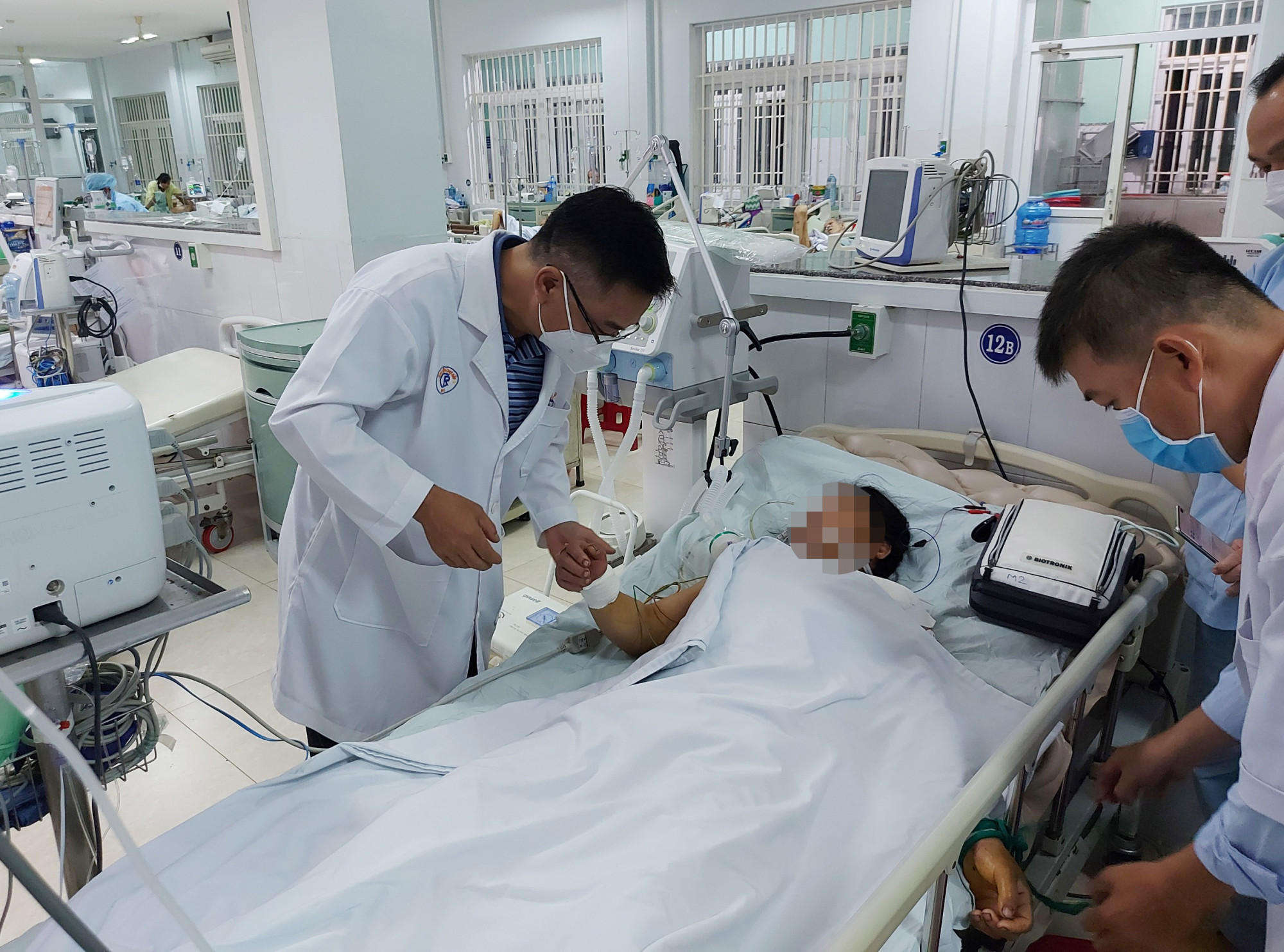 Bác sĩ Quốc Hùng (bên trái) và bác sĩ Thanh Linh (bên phải) xem xét tình trạng bệnh nhân