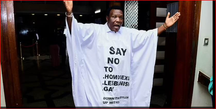 Thành viên Quốc hội John Musira mặc áo choàng có dòng chữ 'nói không với đồng tính luyến ái, chủ nghĩa đồng tính nữ, đồng tính nam' khi ông rời quốc hội Uganda sau cuộc tranh luận về dự luật
