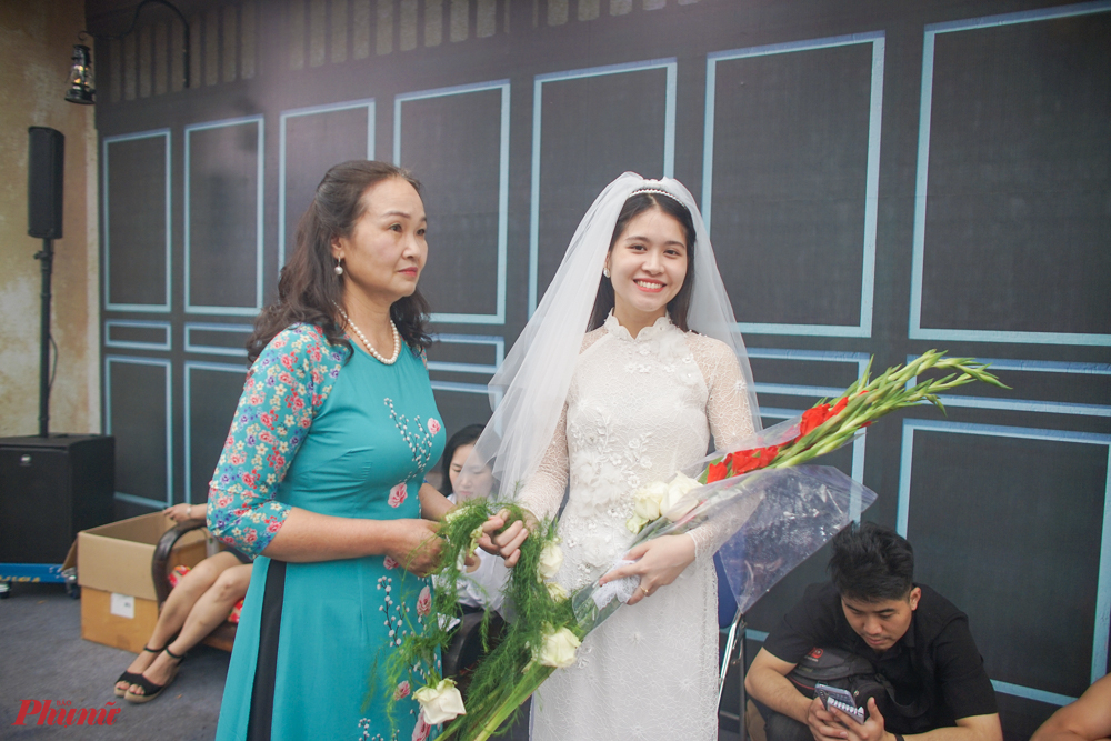 Hình ảnh một cô dâu điển hình của thế kỷ trước với bộ áo cưới là áo dài cưới cách điệu, khăn voan và bó hoa lay ơn.