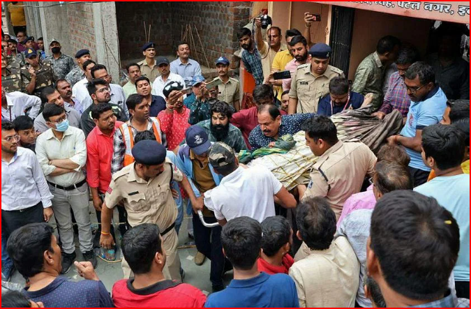 Nhân viên cứu hộ và an ninh khiêng một tín đồ trên cáng bị thương sau khi nắp giếng bị sập bên trong một ngôi đền Hindu ở Indore. ẢNH: AFP