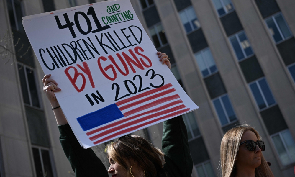 Người dân xuống đường tuần hành phản đối bạo lực súng đạn sau vụ xả súng ở trường tiểu học Covenant, biểu ngữ cho thấy có ít nhất 400 trường hợp trẻ em và thanh thiếu niên Mỹ thiệt mạng vì súng ống chỉ trong 3 tháng đầu năm 2023 – Ảnh: AFP