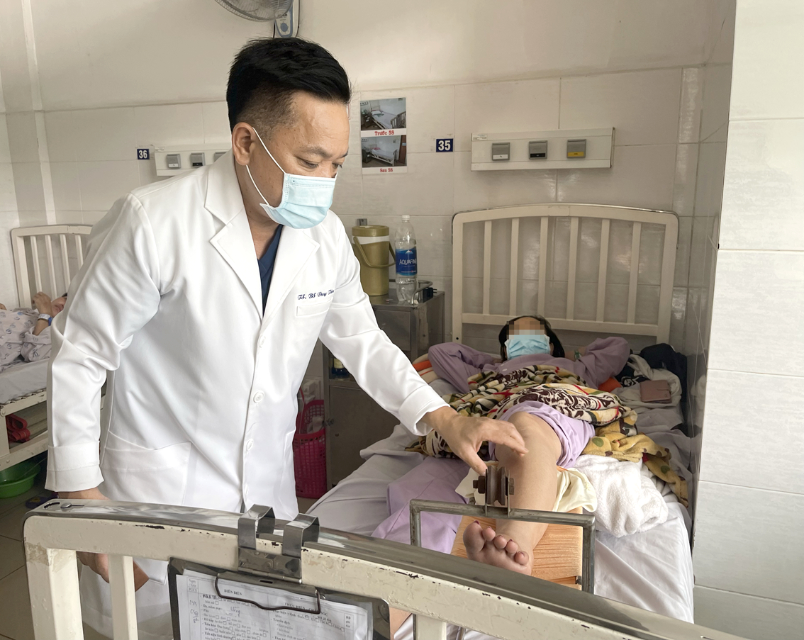 Bác sĩ Nguyễn Duy Tân đang khám cho một bệnh nhân nữ trẻ bị suy van tĩnh mạch gây thuyên tắc tĩnh mạch ở chân - ẢNH: THANH HUYỀN