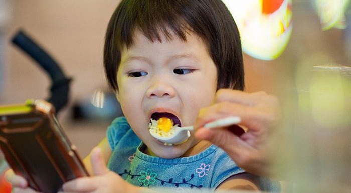(Nhiều cha mẹ cho trẻ lạm dụng điện thoại khi ăn, khi chơi...)