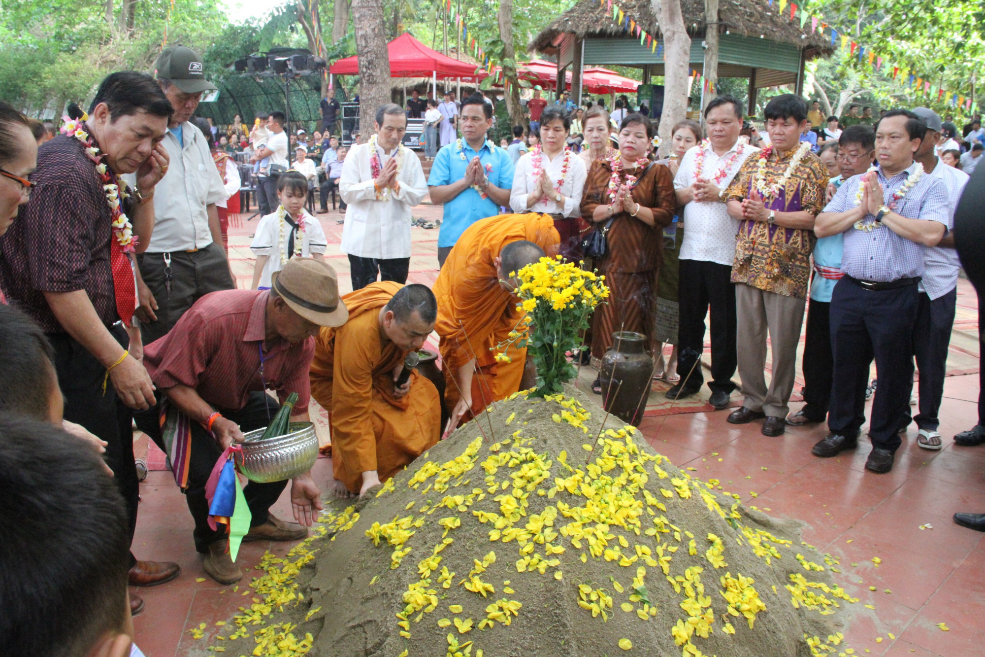 tại Tết Bunpimay, mọi người cùng hành lễ đắp tháp cát. Đây là một trong những phong tục lâu đời của các bộ tộc Lào để cầu chúc sức khỏe, bình an. 