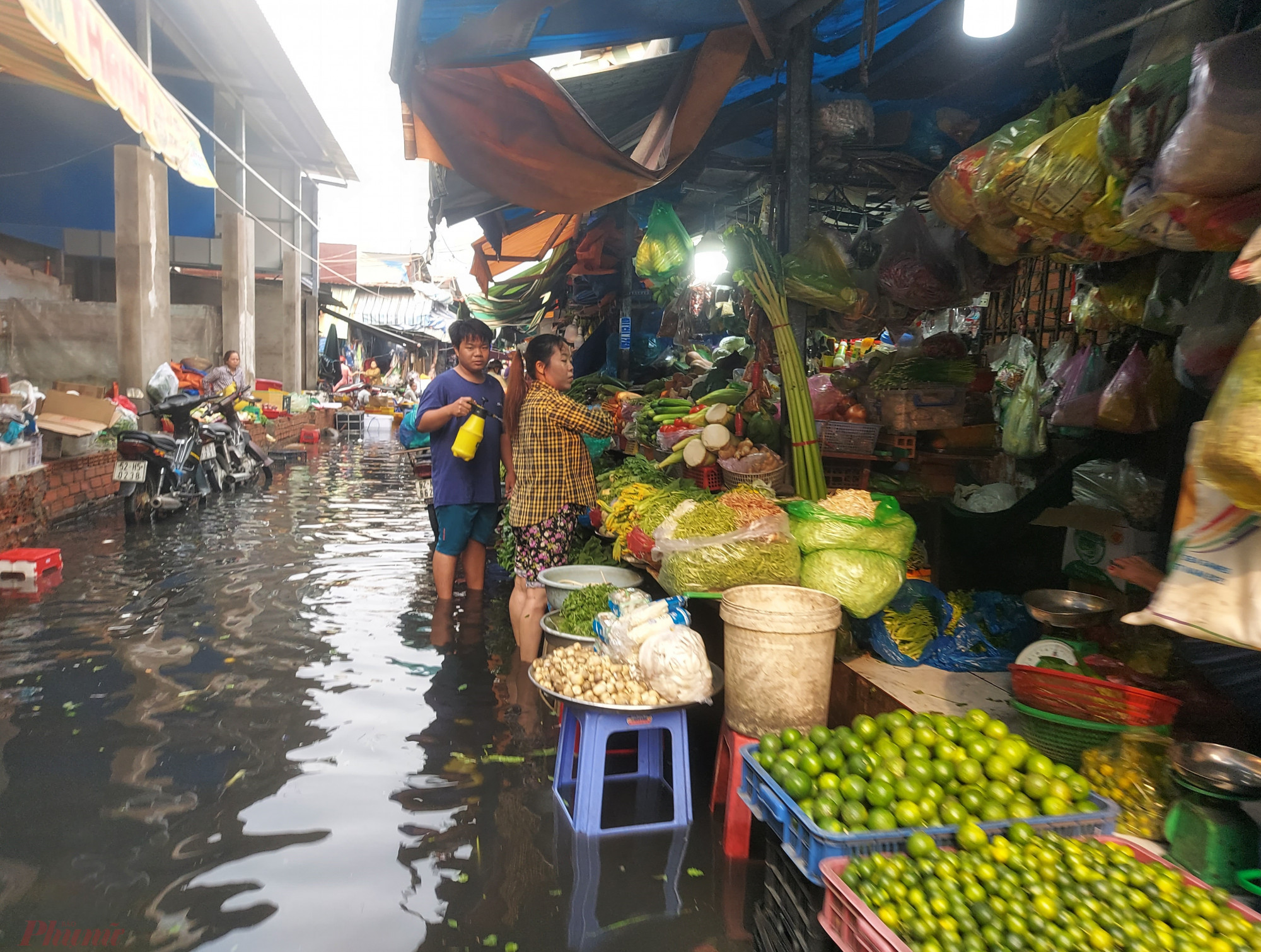 Nhiều tiểu thương chợ khu phố 2 vừa lội nước, vừa bán hàng.