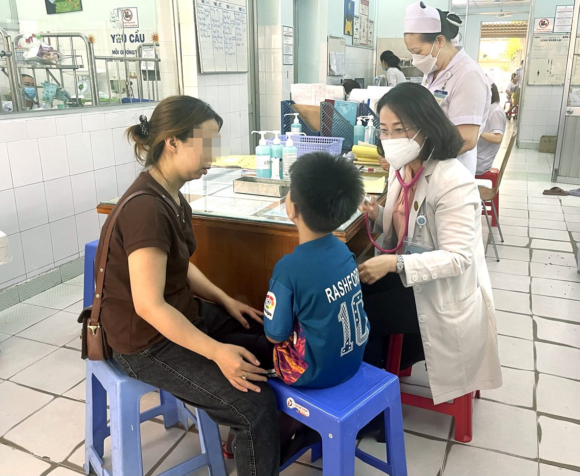 Bác sĩ Nguyễn Thị Thu Thủy đang khám cho một bệnh nhi bị nhiễm trùng  tiêu hóa - ẢNH: THANH HUYỀN