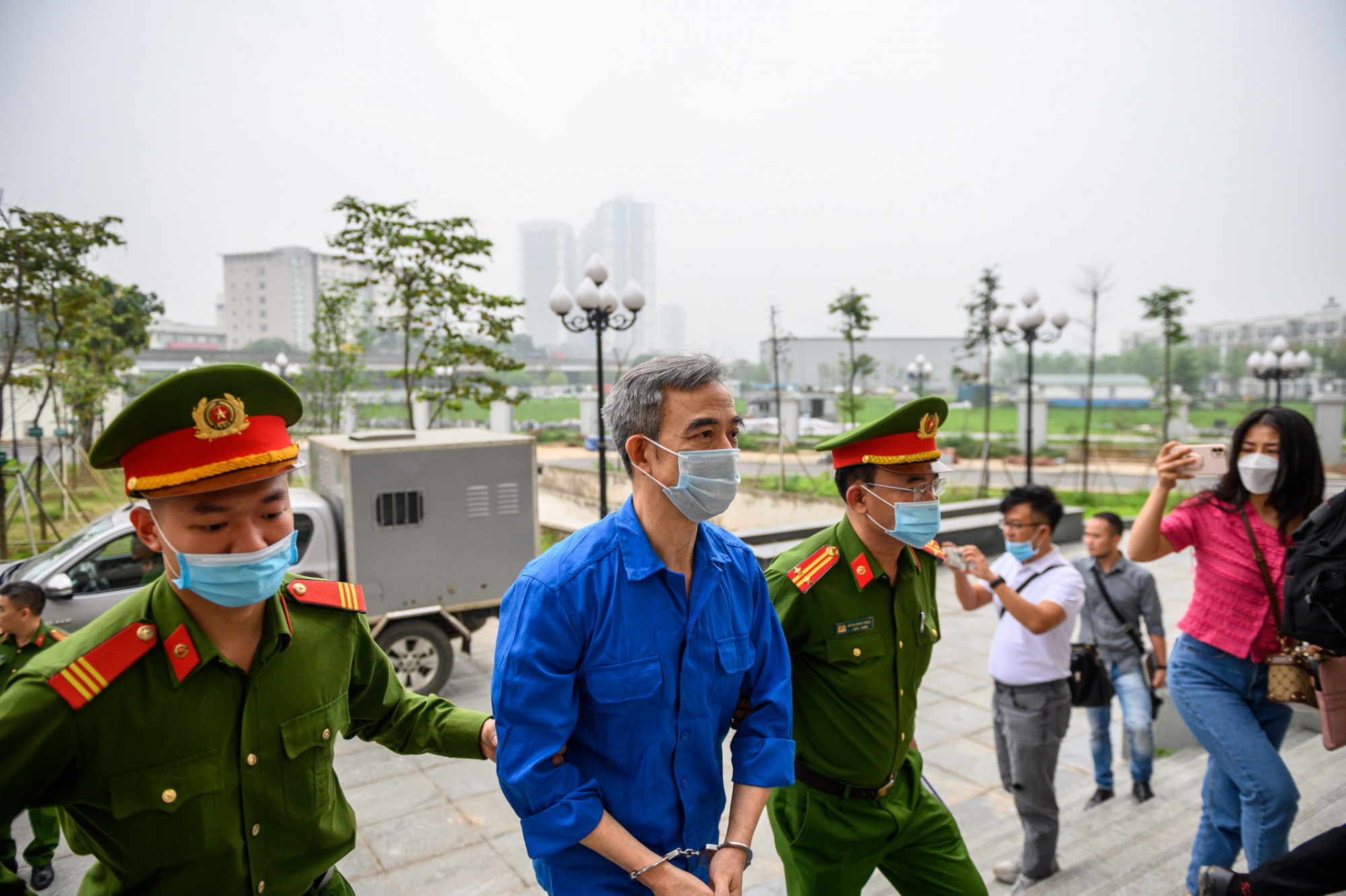 Ông Nguyễn Quang Tuấn được cảnh sát dẫn giải tới phiên xét xử.