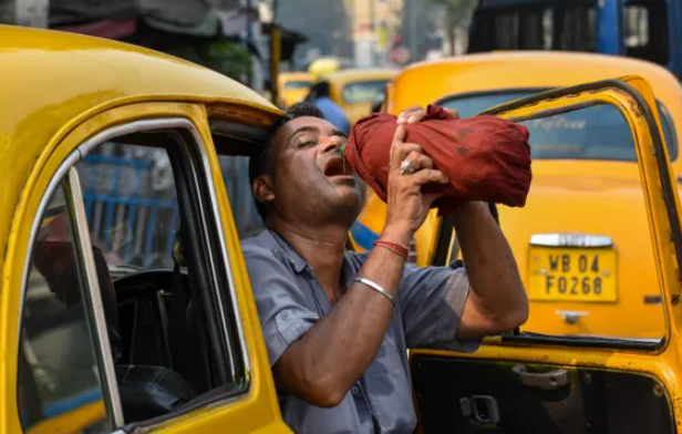 Một tài xế taxi uống nước từ chai trong cái nóng buổi chiều ở Kolkata khi một đợt nắng nóng bao trùm Ấn Độ. Ảnh: Debarchan Chatterjee/NurPhoto/Shutterstock