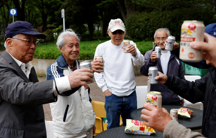 Nomura và các đồng đội của anh ấy đã nâng ly chúc mừng bằng bia tại một công viên sau trận mở màn của giải đấu dành cho lứa tuổi trên 80 của SFL. [Kim Kyung-Hoon/Reuters]