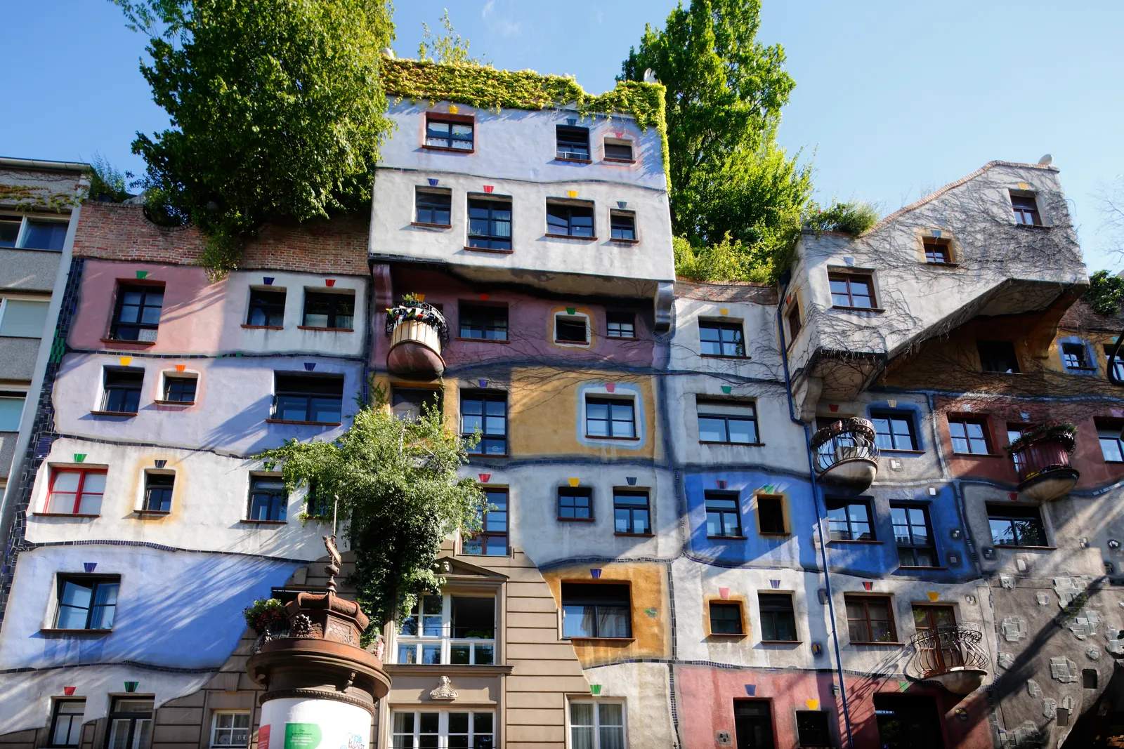 Hundertwasserhaus, Viên, Áo (thiết kế bởi Friedensreich Hundertwasser, 1985) Một trong những điểm thu hút phổ biến nhất của Vienna,  Hundertwasserhaus là dự án kiến ​​trúc đầu tiên của nghệ sĩ Friedensreich Hundertwasser. Với sự hỗ trợ của kiến ​​trúc sư Josef Krawina, Hundertwasser đã hình dung ra một ngôi nhà tương tác với thiên nhiên. Ngày nay, Hundertwasserhaus, một nơi ở có màu chủ đạo bao gồm các đường dốc và khảm sáng bóng, thuộc sở hữu của chính phủ Vienna, chịu trách nhiệm cho thuê các đơn vị. Mặc dù khách du lịch không thể vào bên trong, nhưng đừng sợ, vì Bảo tàng Hundertwasser chỉ cách đó một quãng đi bộ ngắn.
