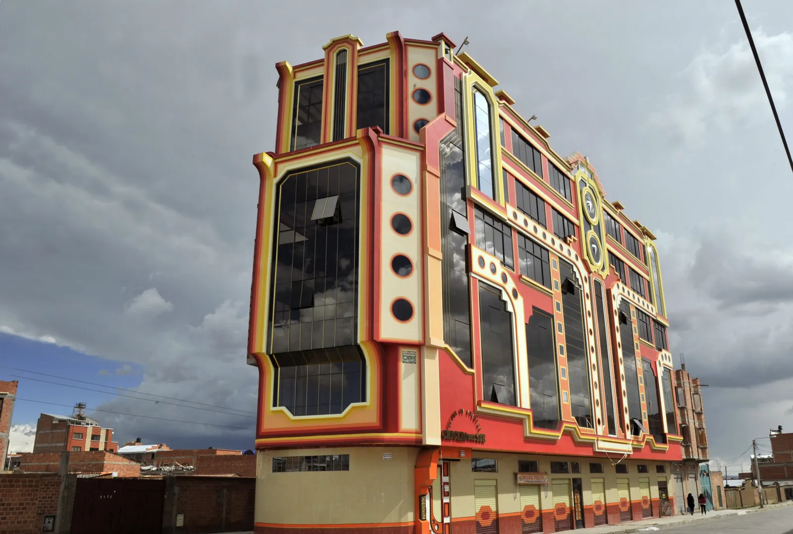 El Alto Cholets, El Alto, Bolivia (thiết kế bởi Freddy Mamani Silvestre, 2005) Nằm ngay bên ngoài thủ đô La Paz,  El Alto Cholets của Freddy Mamani Silvestre là sự khai hoang của nền văn hóa Andean. Những ngôi nhà cholet sống động, theo chủ nghĩa tối đa này—từ ghép của “chalet” và “chola”—bày tỏ lòng kính trọng đối với người dân bản địa Bolivia và phản đối trực tiếp các tông màu trầm truyền thống và gạch lộ ra ngoài của kiến ​​trúc Bolivian hiện đại. Cholets là tòa nhà đa năng, với tầng một được sử dụng cho các doanh nghiệp thương mại, tầng thứ hai là không gian tổ chức sự kiện và tầng thứ ba dành cho căn hộ.