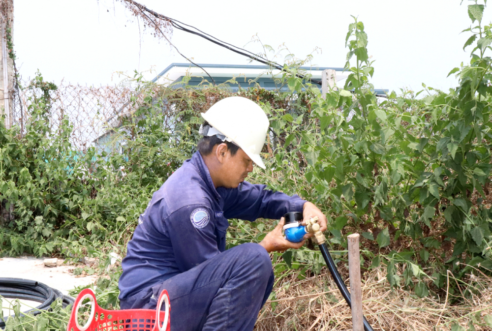 Nhân viên Xí nghiệp Cấp nước Cần Giờ gắn mới đồng hồ nước tại nhà bà Nguyễn Thị Ngọc Thúy