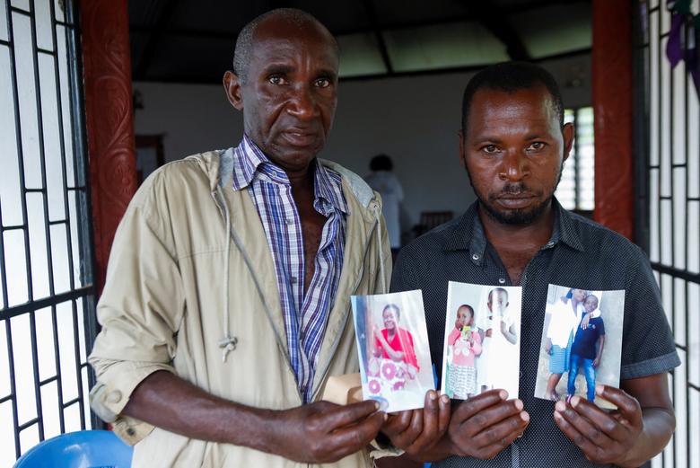 Herbell Farasi và anh rể Mwachai Dzombo cầm ảnh của vợ mình là Judith Farasi, một tín đồ của Nhà thờ Good News International, bên ngoài nhà xác bệnh viện quận Malindi, ngày 26 tháng 4. REUTERS/Monicah Mwangi