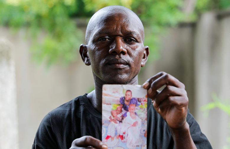 Steven Mwiti cầm bức ảnh của người vợ quá cố Joan Bahati. Mwiti quá quẫn trí nên không thể nhận dạng thi thể của vợ và 6 đứa con trong số xác của hàng chục thành viên giáo phái. Các con tôi đã mất rồi. Những đứa trẻ đã được giải cứu. Tôi đã đi tìm và không thấy các con của mình, Mwiti nói trong khi vẫy tấm ảnh của vợ và 4 đứa con. Anh ấy đã mang theo bức ảnh tai chó, phai màu trong một chiếc túi nhựa trong khoảng sáu tháng qua khi anh ấy tìm kiếm những đứa trẻ của mình. REUTERS/Monicah Mwangi