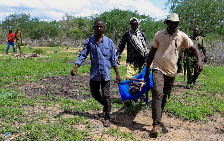Các sĩ quan cảnh sát và dân thường Kenya giải cứu một đứa trẻ tiều tụy trong rừng Shakahola, ngày 24 tháng Tư .