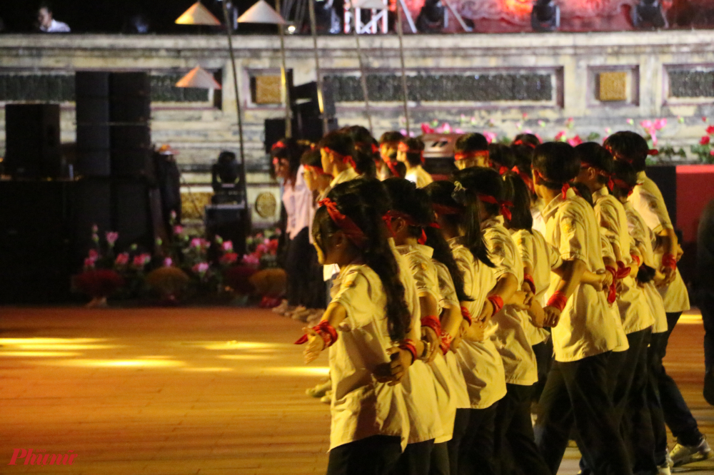 100 tình nguyện viên là những học sinh trường THPT chuyên Quốc học Huế và THPT Hai Bà Trưng cùng múa phụ họa