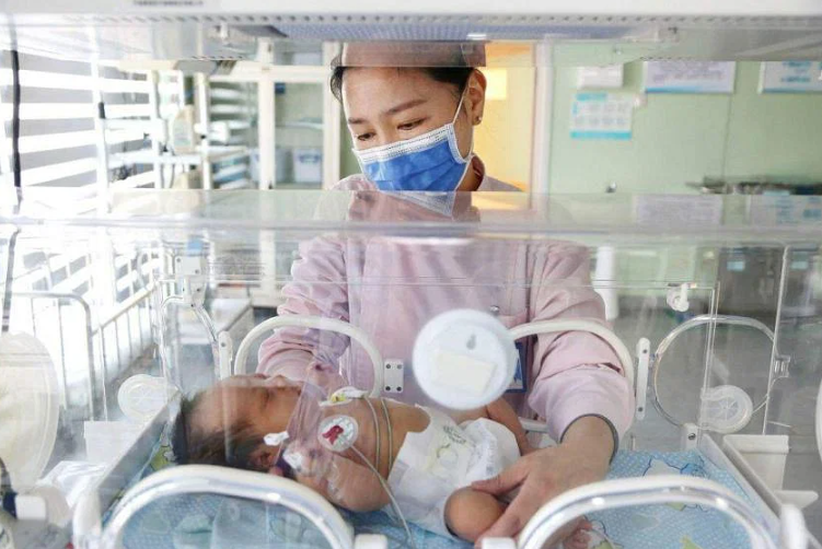 Một nhân viên y tế chăm sóc một em bé sơ sinh tại một bệnh viện ở Liên Vân Cảng, tỉnh Chiết Giang, phía đông Trung Quốc vào ngày 8/3. Ảnh: AFP